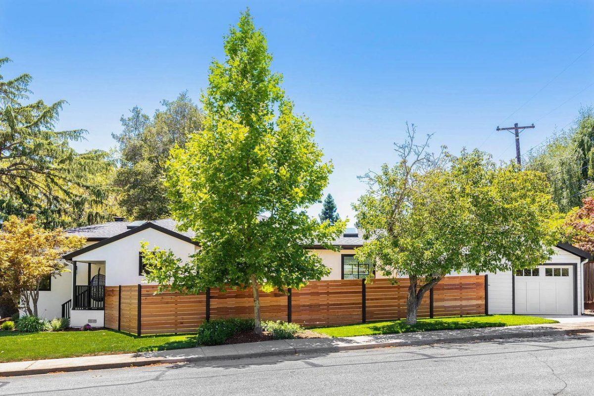 A house with a fence and trees in the background