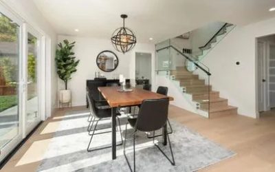 A dining room table with chairs and a plant in the middle.