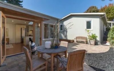 A patio with chairs and table outside of the house.