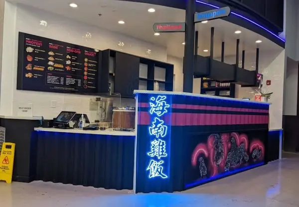 A restaurant with neon lights and a counter.