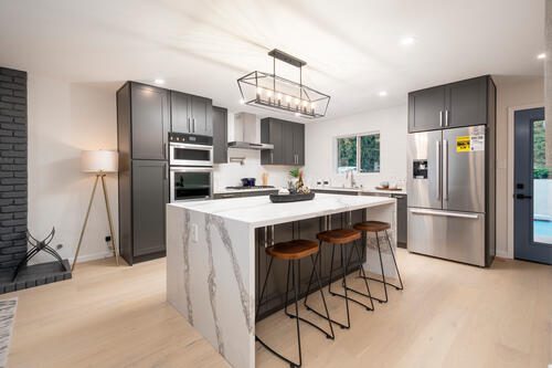 A kitchen with a large island and stainless steel appliances.