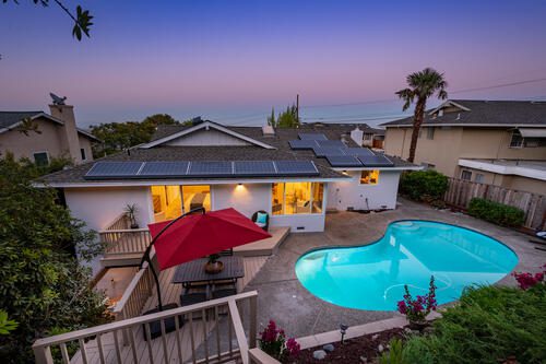 A house with a pool and patio furniture.