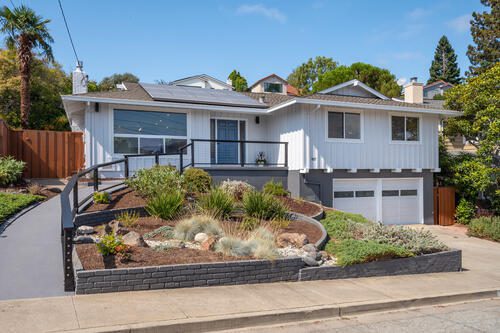 A house with a driveway and steps leading to the front door.