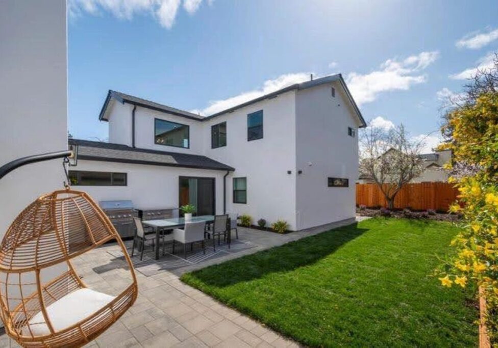 A backyard with a lawn and patio furniture.